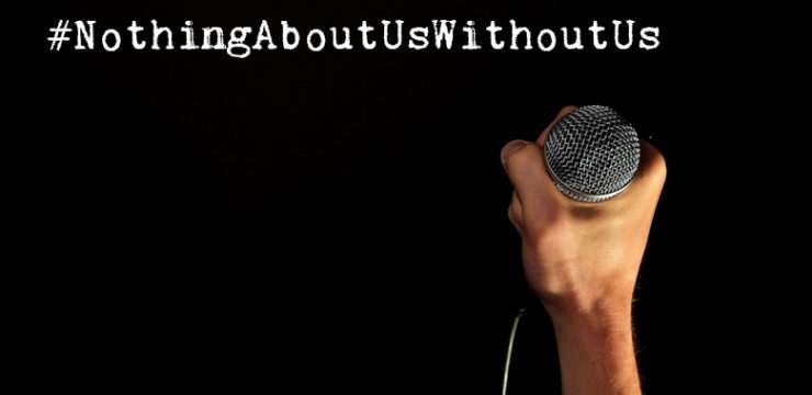 On a black background, a hand holds up a microphone. In white text, it reads: #NothingAboutUsWithoutUs