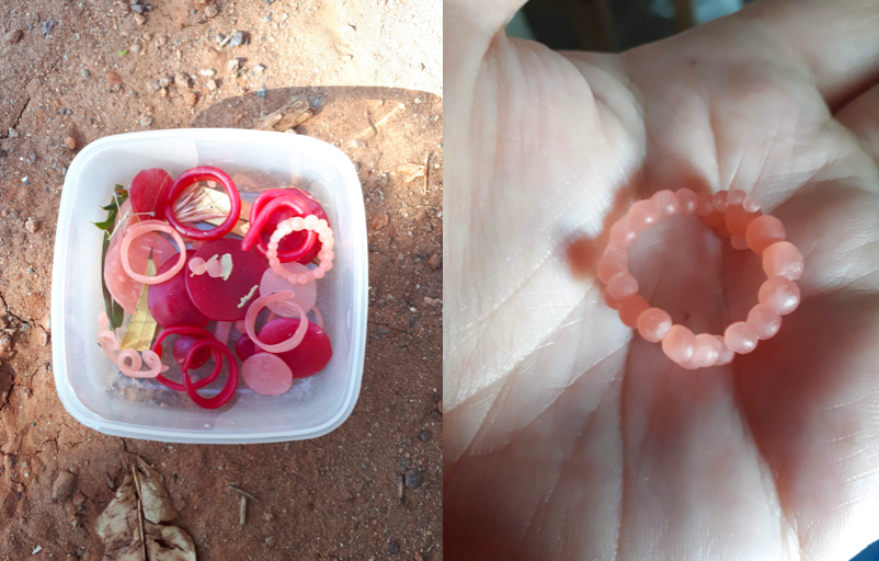 Two images, the first showing a box of red, pink and orange rings in different shapes and sizes. The next image shows one of the rings in the palm of a hand. The ring is made up of small balls that glow orange, invoking themes of red dirt of Alice Springs.